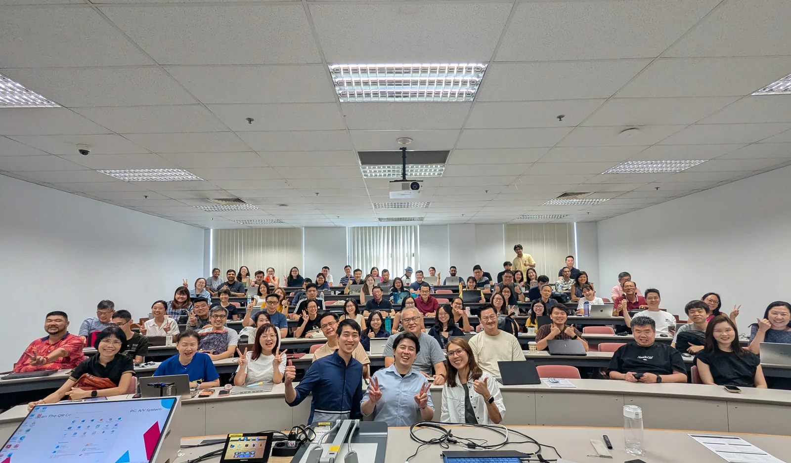 Overpowered AI workshop cohort at SIM — participants raise peace signs at close of session